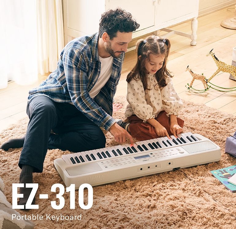 Father and daughter happily playing the EZ-310 on the floor.
