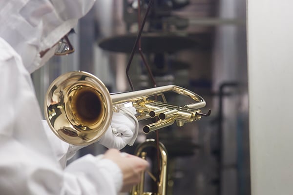 Un trabajador limpiando un instrumento musical durante el proceso de lavado en una fábrica de Yamaha.
