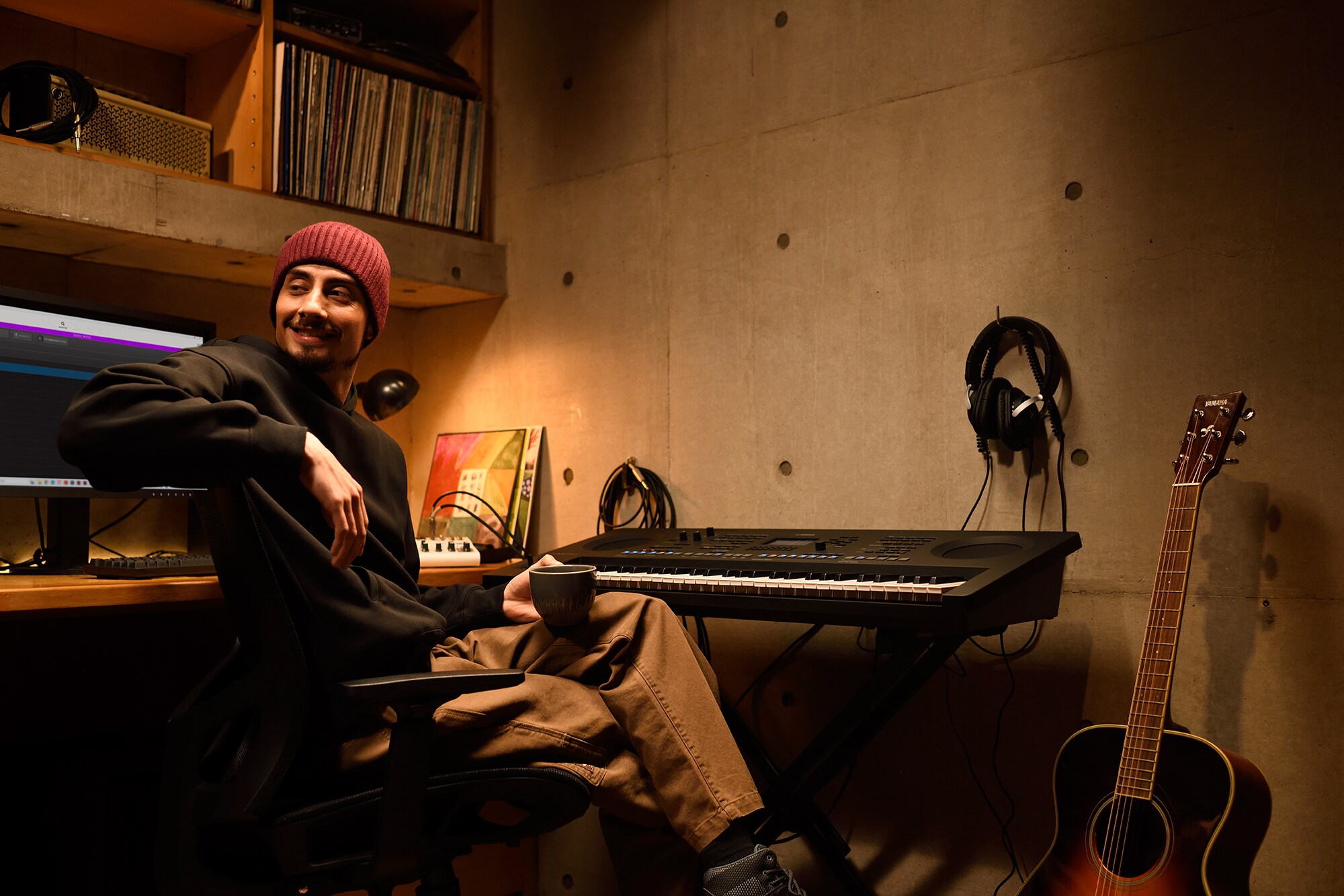 Un espacio de trabajo musical en casa con un ordenador y un teclado, que muestra a un teclista trabajando en su estudio doméstico