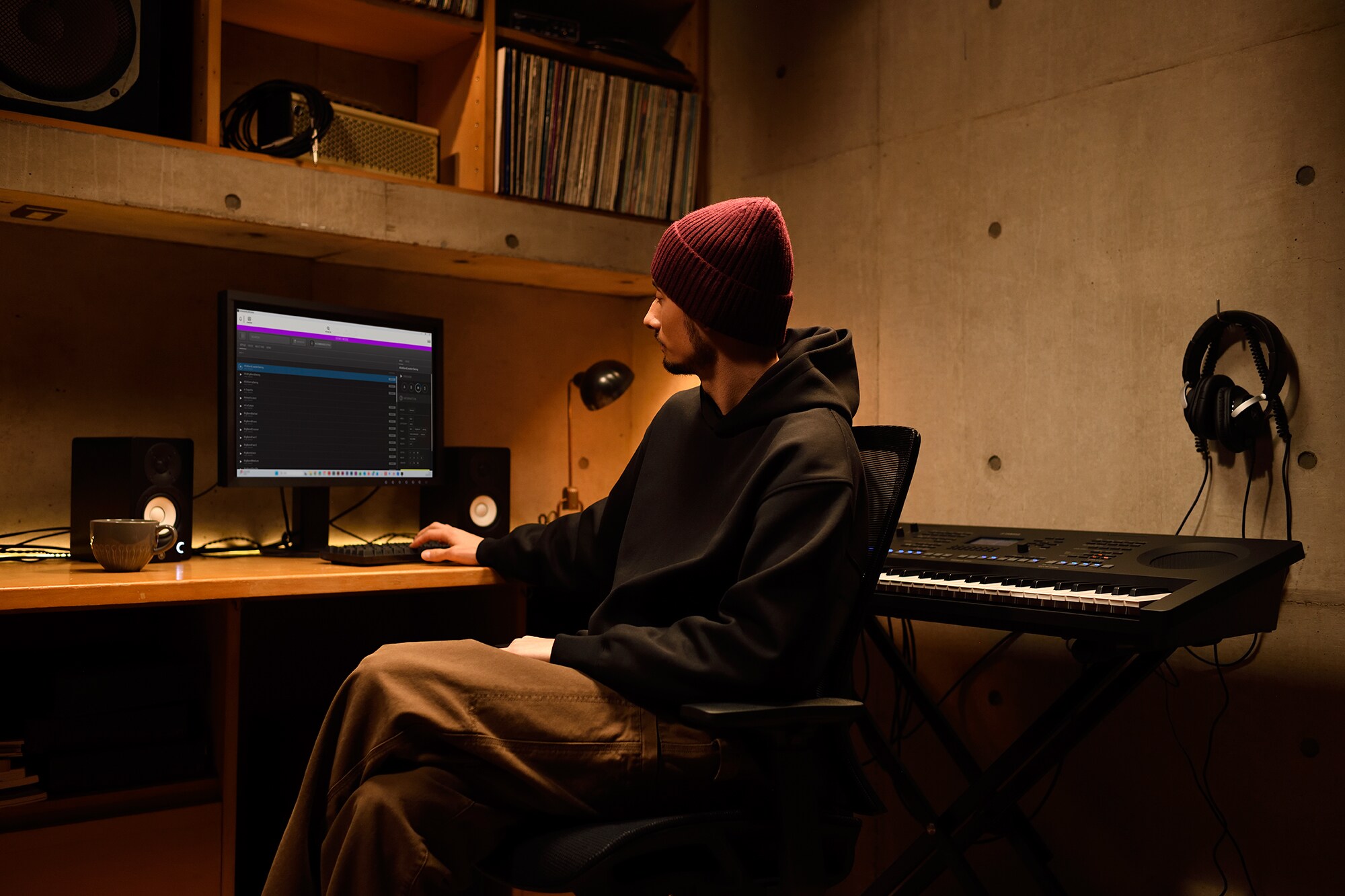 Un espacio de trabajo musical en casa con un ordenador y un teclado, que muestra a un teclista trabajando en su estudio doméstico