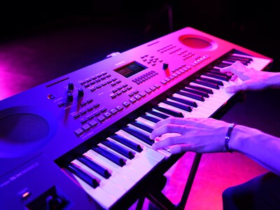 Primer plano de unas manos tocando un teclado durante una interpretación en directo.
