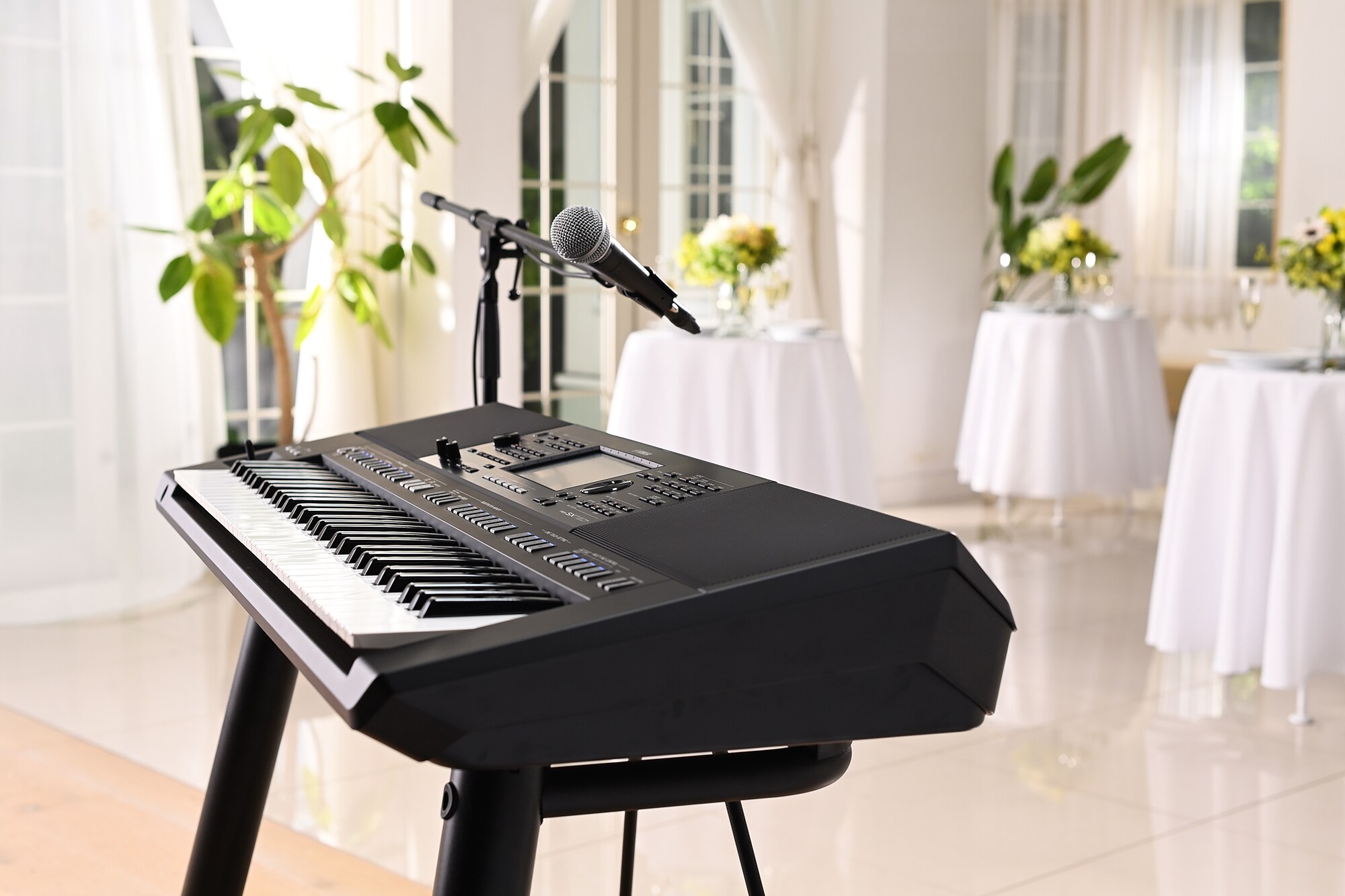 Yamaha Arranger Workstation PSR‑SX720+ con soporte de micrófono en un local de fiesta