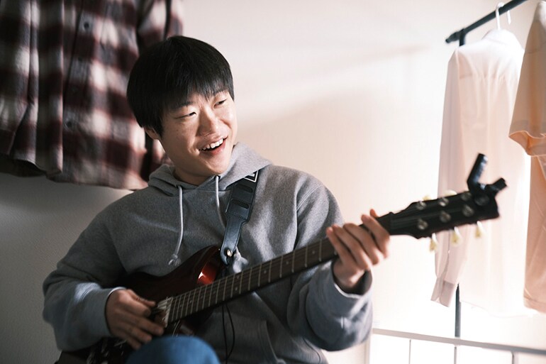 Un hombre intentando tocar la guitarra por primera vez