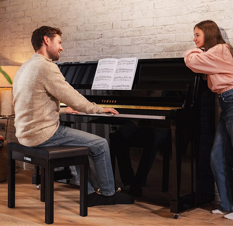 Una madre y su hija disfrutan tocando el piano vertical de la Serie B