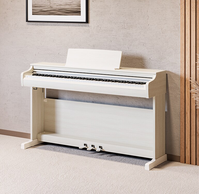 Un salón con un piano ARIUS en abedul blanco, con plantas de interior y un sofá, integrado de forma armoniosa en la decoración