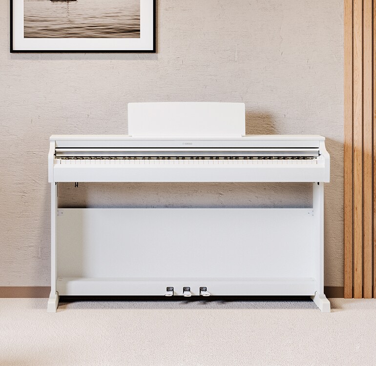 Un salón con un piano ARIUS blanco, con plantas de interior y un sofá, integrado de forma armoniosa en la decoración