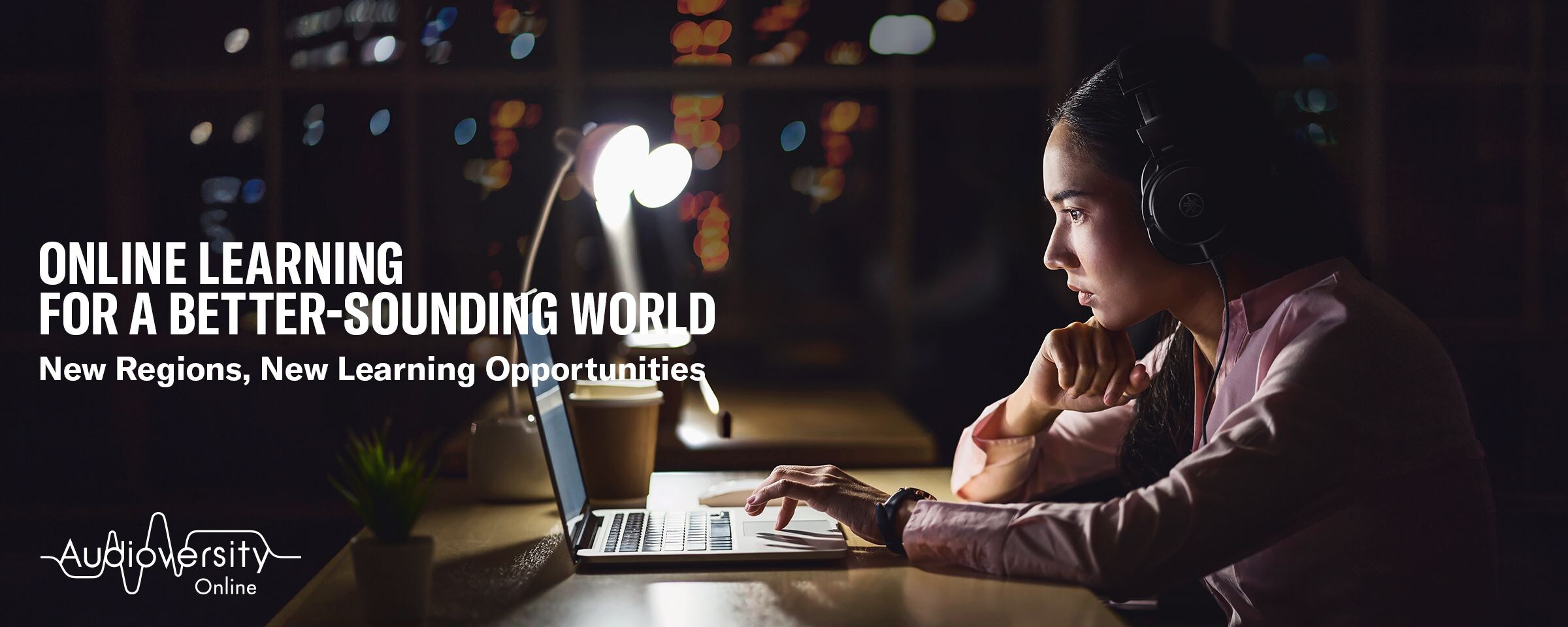 Key visual for Audioversity Online: a woman focused on an online training session.