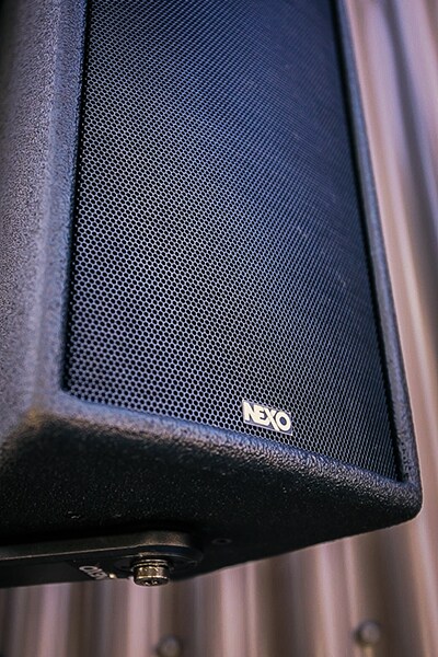 Close-up of a wall-mounted NEXO loudspeaker installed inside the venue.